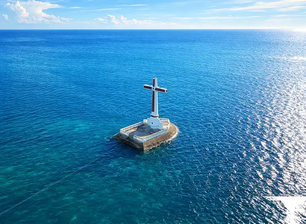 Underwater cross monument at Sunken Cemetery Camiguin with batfish